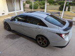2023 Hyundai Elantra N in perfect condition with aftermarket wheels and custom accents parked outdoors.