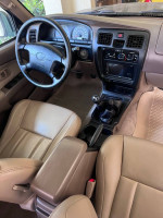 Interior view of a 1999 Toyota 4Runner SR5 with manual transmission and beige leather seats.