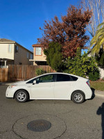 Side view of a 2011 Toyota Prius Hybrid parked, showcasing its sleek design and sunny surroundings.
