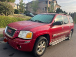2002 GMC Envoy in red with clean exterior, showcasing its spacious design and family-friendly features.