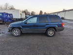 2002 Jeep Grand Cherokee with plow attachment and 122,000 miles parked in a lot