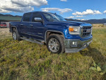 2014 GMC Sierra 1500 SLT 4WD in cobalt blue, showcasing chrome accents and a rugged design.
