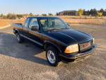 1999 GMC Sonoma SLS Sport 4WD truck in black, showing exterior details and nearby landscape.