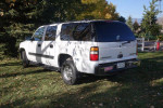 2005 Chevrolet Suburban LS 4WD parked on grass with trees in the background, showcasing its exterior features.