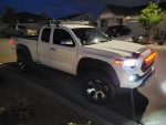 2017 Toyota Tacoma 4x4 Extended Cab parked at night, featuring off-road tires and LED lights.