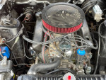 Engine bay of a 1970 Ford Mustang with a new 302 crate engine and red air filter