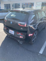 Rear view of a 2014 BMW i3 with Range Extender, showcasing its sleek design and HOV lane sticker.