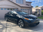 2014 Honda Civic EX Coupe in black color parked in front of a house, showcasing its stylish design and alloy wheels.