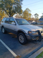 2001 Honda Passport EX RWD parked, shows signs of wear with cracked radiator and old tires, priced at $2500.